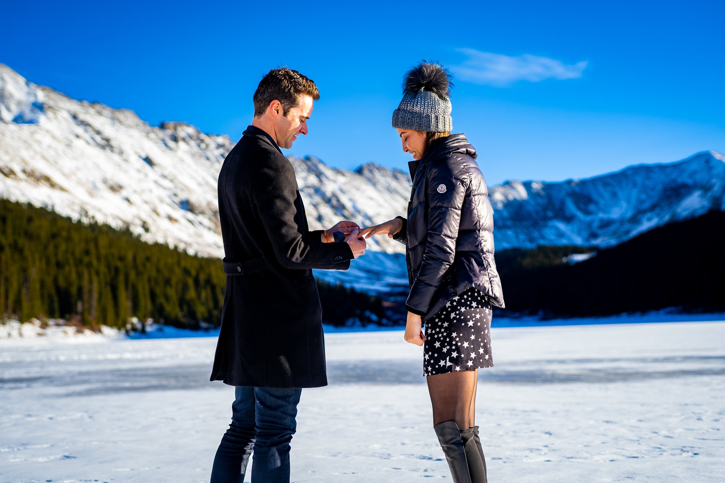 Man proposes to girlfriend while standing on a frozen lake with snowcapped mountains in the background, Engagement Session, Engagement Photos, Engagement Photos Inspiration, Engagement Photography, Engagement Photographer, Winter Engagement Photos, Proposal Photos, Proposal Photographer, Proposal Photography, Winter Proposal, Mountain Proposal, Proposal Inspiration, Summit County engagement session, Summit County engagement photos, Summit County engagement photography, Summit County engagement photographer, Summit County engagement inspiration, Colorado engagement session, Colorado engagement photos, Colorado engagement photography, Colorado engagement photographer, Colorado engagement inspiration, Clinton Gulch Engagement