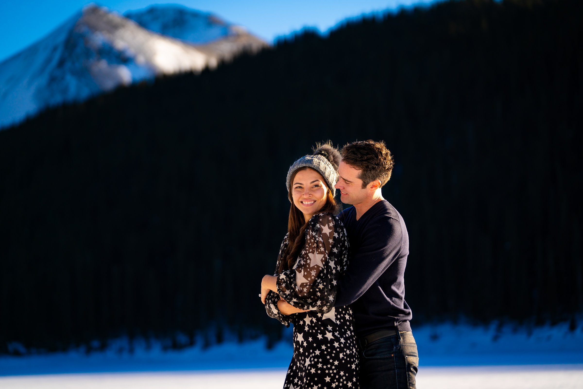 Newly engaged couple celebrate their proposal on a frozen lake with snowcapped mountains in the background, Engagement Session, Engagement Photos, Engagement Photos Inspiration, Engagement Photography, Engagement Photographer, Winter Engagement Photos, Proposal Photos, Proposal Photographer, Proposal Photography, Winter Proposal, Mountain Proposal, Proposal Inspiration, Summit County engagement session, Summit County engagement photos, Summit County engagement photography, Summit County engagement photographer, Summit County engagement inspiration, Colorado engagement session, Colorado engagement photos, Colorado engagement photography, Colorado engagement photographer, Colorado engagement inspiration, Clinton Gulch Engagement