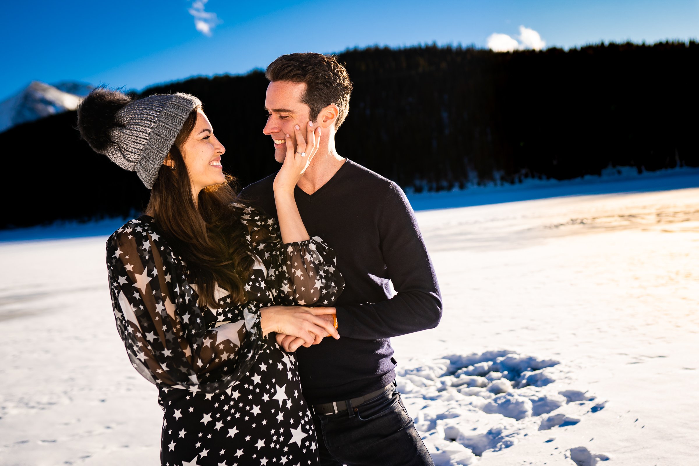 Newly engaged couple celebrate their proposal on a frozen lake with snowcapped mountains in the background, Engagement Session, Engagement Photos, Engagement Photos Inspiration, Engagement Photography, Engagement Photographer, Winter Engagement Photos, Proposal Photos, Proposal Photographer, Proposal Photography, Winter Proposal, Mountain Proposal, Proposal Inspiration, Summit County engagement session, Summit County engagement photos, Summit County engagement photography, Summit County engagement photographer, Summit County engagement inspiration, Colorado engagement session, Colorado engagement photos, Colorado engagement photography, Colorado engagement photographer, Colorado engagement inspiration, Clinton Gulch Engagement