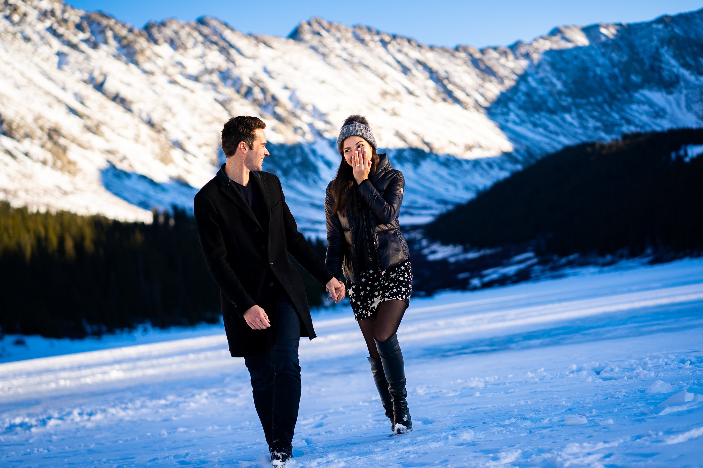 Newly engaged couple celebrate their proposal on a frozen lake with snowcapped mountains in the background, Winter Engagement Session, Winter Engagement Photos, Engagement Photos Inspiration, Engagement Photography, Engagement Photographer, Winter Engagement Photos, Proposal Photos, Proposal Photographer, Proposal Photography, Winter Proposal, Mountain Proposal, Proposal Inspiration, Summit County engagement session, Summit County engagement photos, Summit County engagement photography, Summit County engagement photographer, Summit County engagement inspiration, Colorado engagement session, Colorado engagement photos, Colorado engagement photography, Colorado engagement photographer, Colorado engagement inspiration, Clinton Gulch Engagement