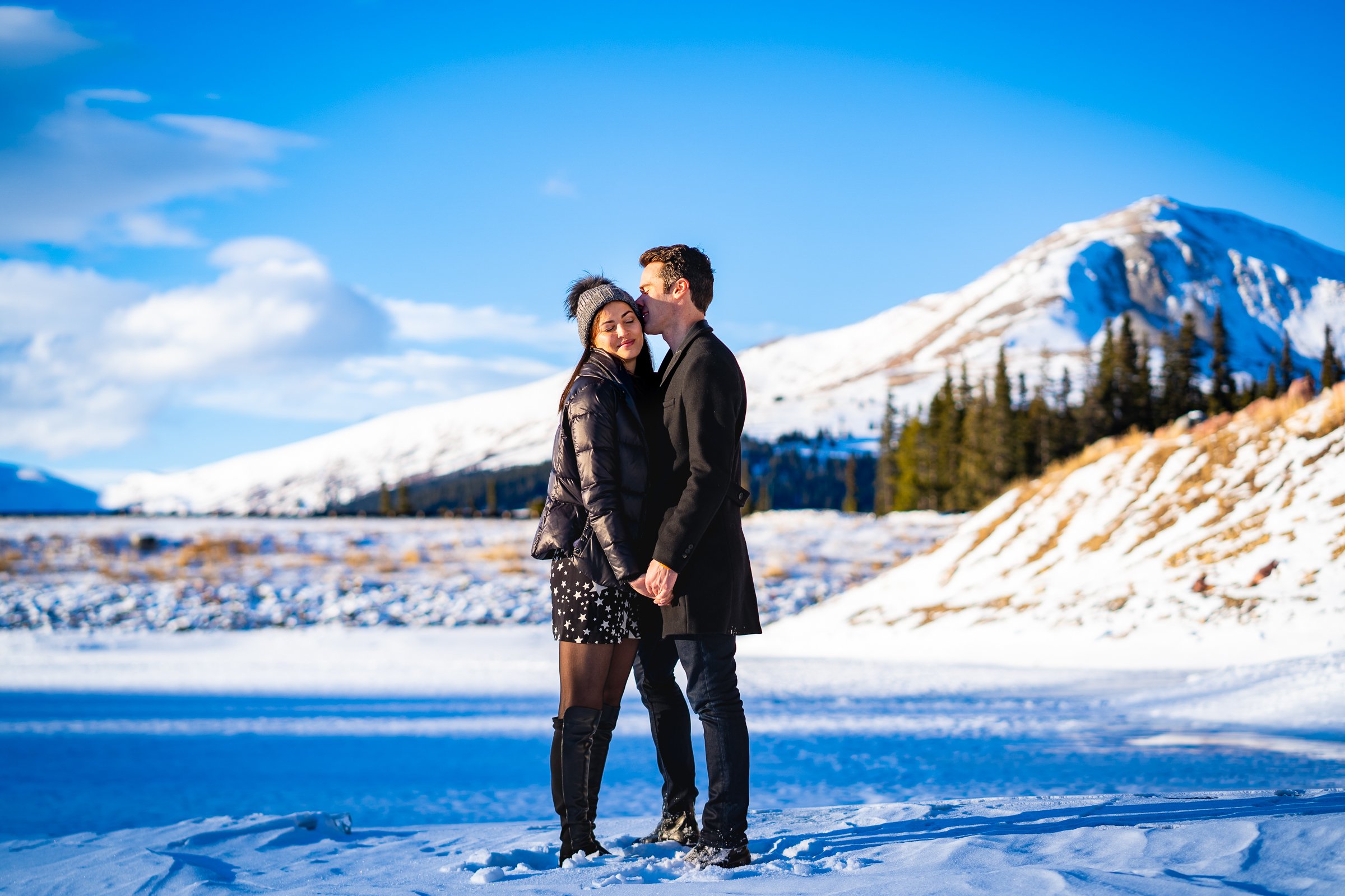 Newly engaged couple celebrate their proposal on a frozen lake with snowcapped mountains in the background, Winter Engagement Session, Winter Engagement Photos, Engagement Photos Inspiration, Engagement Photography, Engagement Photographer, Winter Engagement Photos, Proposal Photos, Proposal Photographer, Proposal Photography, Winter Proposal, Mountain Proposal, Proposal Inspiration, Summit County engagement session, Summit County engagement photos, Summit County engagement photography, Summit County engagement photographer, Summit County engagement inspiration, Colorado engagement session, Colorado engagement photos, Colorado engagement photography, Colorado engagement photographer, Colorado engagement inspiration, Clinton Gulch Engagement