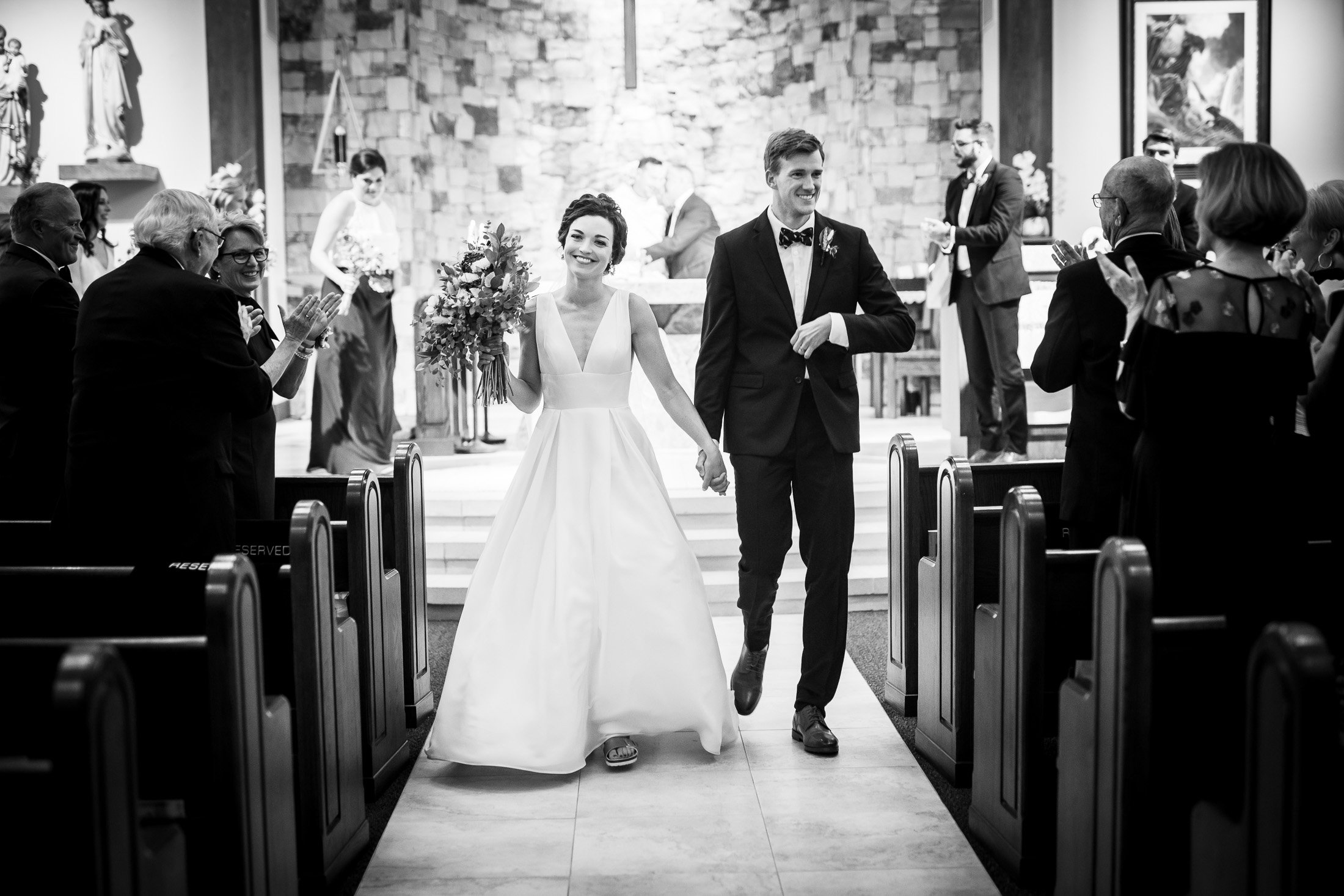 Bride and groom celebrate as newlyweds as they walk down the aisle during the recessional at their catholic wedding ceremony at the church, wedding, wedding photos, wedding photography, wedding photographer, wedding inspiration, wedding photo inspiration, wedding portraits, wedding ceremony, wedding reception, mountain wedding, Catholic Church wedding, Catholic Church wedding photos, Catholic Church wedding photography, Catholic Church wedding photographer, Catholic Church wedding inspiration, Catholic Church wedding venue, Steamboat Springs wedding, Steamboat Springs wedding photos, Steamboat Springs wedding photography, Steamboat Springs wedding photographer, Colorado wedding, Colorado wedding photos, Colorado wedding photography, Colorado wedding photographer, Colorado mountain wedding, Colorado wedding inspiration