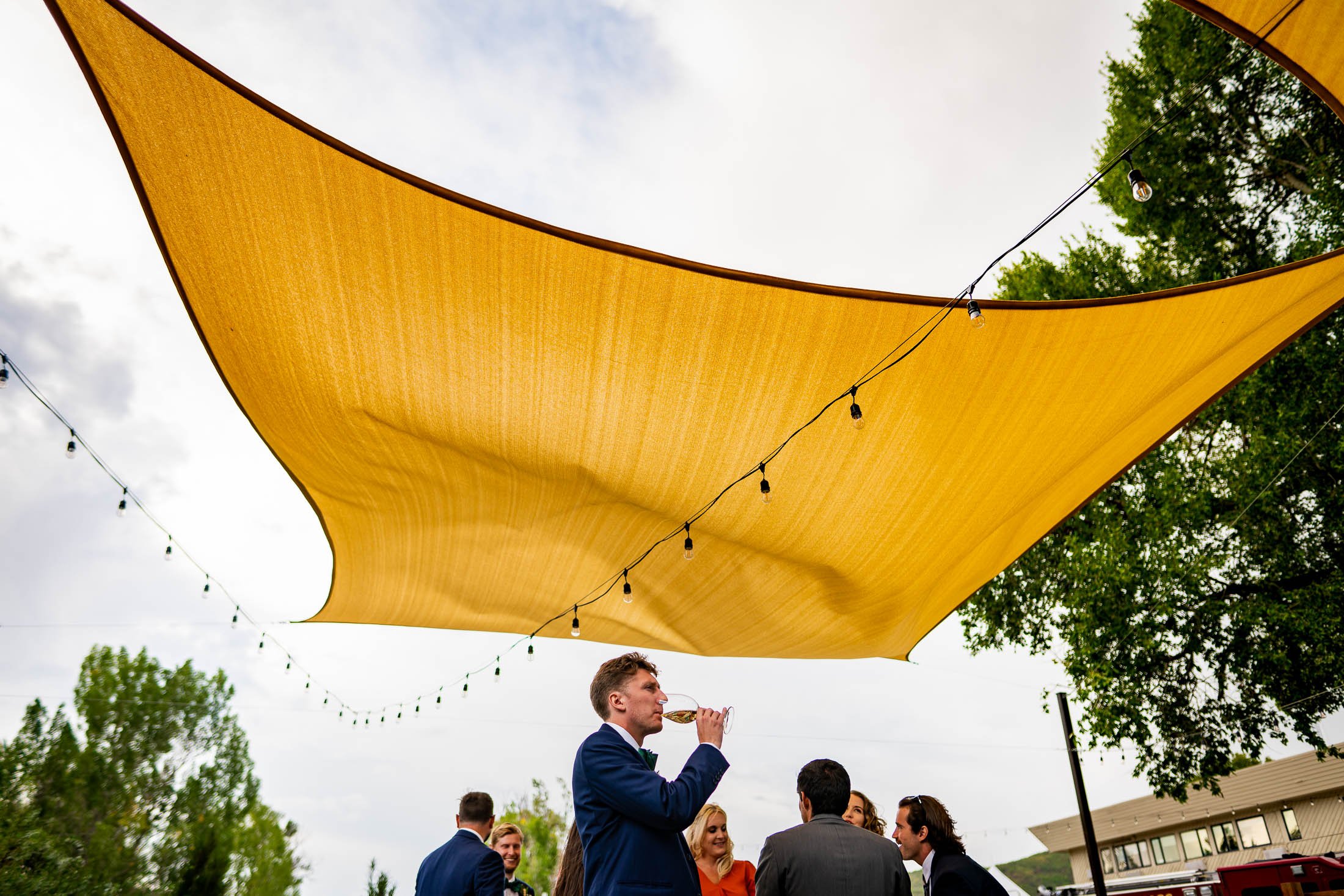 Wedding guests mingle on an outdoor patio during cocktail hour, wedding, wedding photos, wedding photography, wedding photographer, wedding inspiration, wedding photo inspiration, wedding portraits, wedding ceremony, wedding reception, mountain wedding, Catholic Church wedding, Catholic Church wedding photos, Catholic Church wedding photography, Catholic Church wedding photographer, Catholic Church wedding inspiration, Catholic Church wedding venue, Steamboat Springs wedding, Steamboat Springs wedding photos, Steamboat Springs wedding photography, Steamboat Springs wedding photographer, Colorado wedding, Colorado wedding photos, Colorado wedding photography, Colorado wedding photographer, Colorado mountain wedding, Colorado wedding inspiration