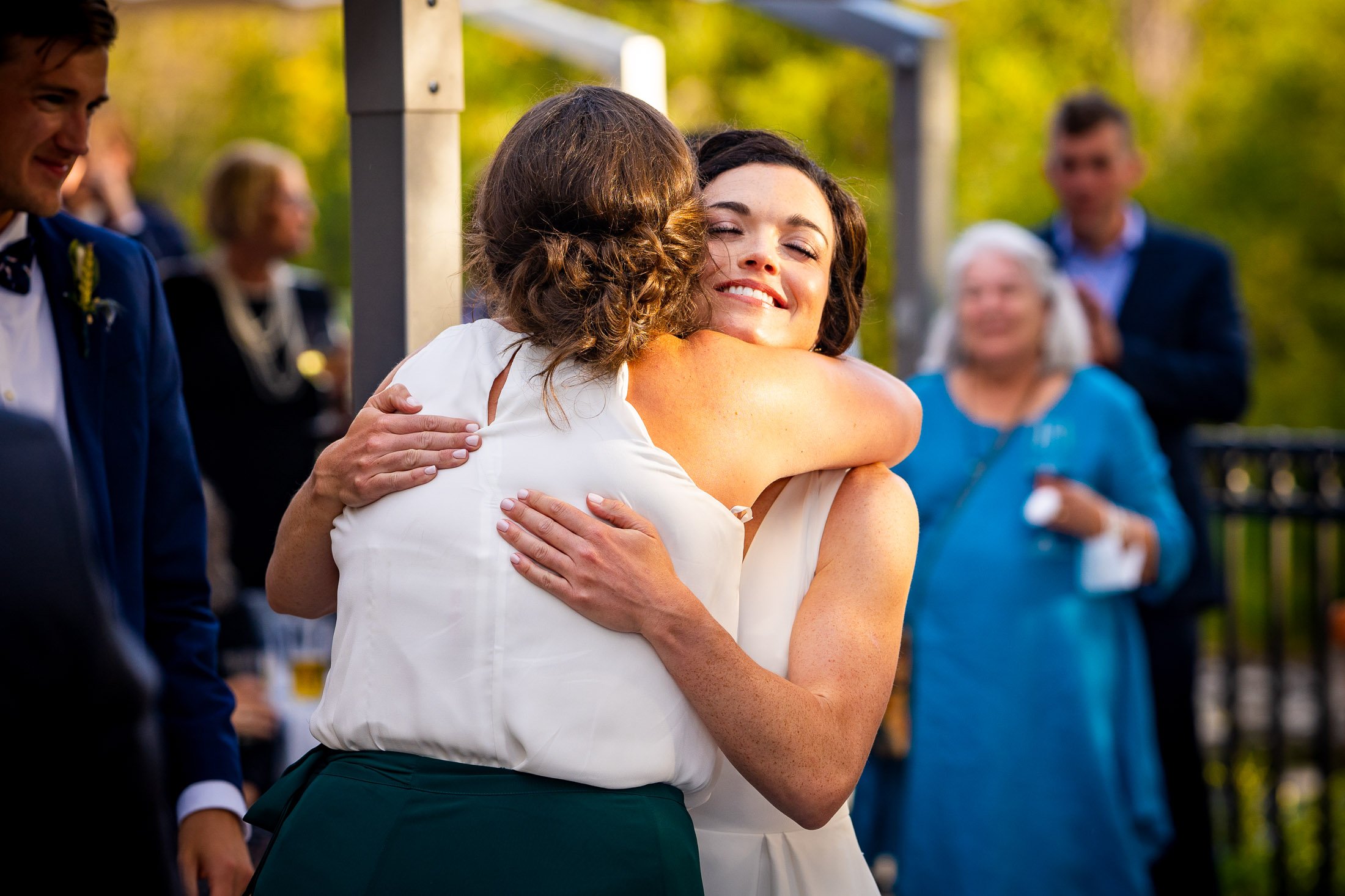 Bride and groom react to reception speeches while sitting on outdoor patio during the wedding reception, wedding, wedding photos, wedding photography, wedding photographer, wedding inspiration, wedding photo inspiration, wedding portraits, wedding ceremony, wedding reception, mountain wedding, Catholic Church wedding, Catholic Church wedding photos, Catholic Church wedding photography, Catholic Church wedding photographer, Catholic Church wedding inspiration, Catholic Church wedding venue, Steamboat Springs wedding, Steamboat Springs wedding photos, Steamboat Springs wedding photography, Steamboat Springs wedding photographer, Colorado wedding, Colorado wedding photos, Colorado wedding photography, Colorado wedding photographer, Colorado mountain wedding, Colorado wedding inspiration