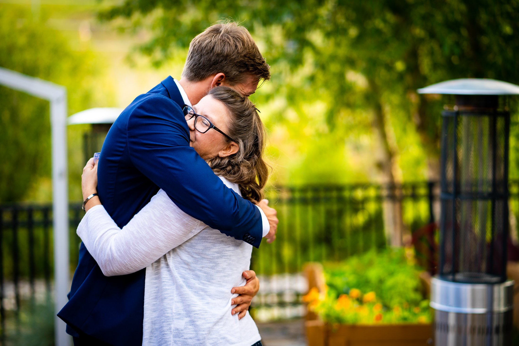 Bride and groom react to reception speeches while sitting on outdoor patio during the wedding reception, wedding, wedding photos, wedding photography, wedding photographer, wedding inspiration, wedding photo inspiration, wedding portraits, wedding ceremony, wedding reception, mountain wedding, Catholic Church wedding, Catholic Church wedding photos, Catholic Church wedding photography, Catholic Church wedding photographer, Catholic Church wedding inspiration, Catholic Church wedding venue, Steamboat Springs wedding, Steamboat Springs wedding photos, Steamboat Springs wedding photography, Steamboat Springs wedding photographer, Colorado wedding, Colorado wedding photos, Colorado wedding photography, Colorado wedding photographer, Colorado mountain wedding, Colorado wedding inspiration