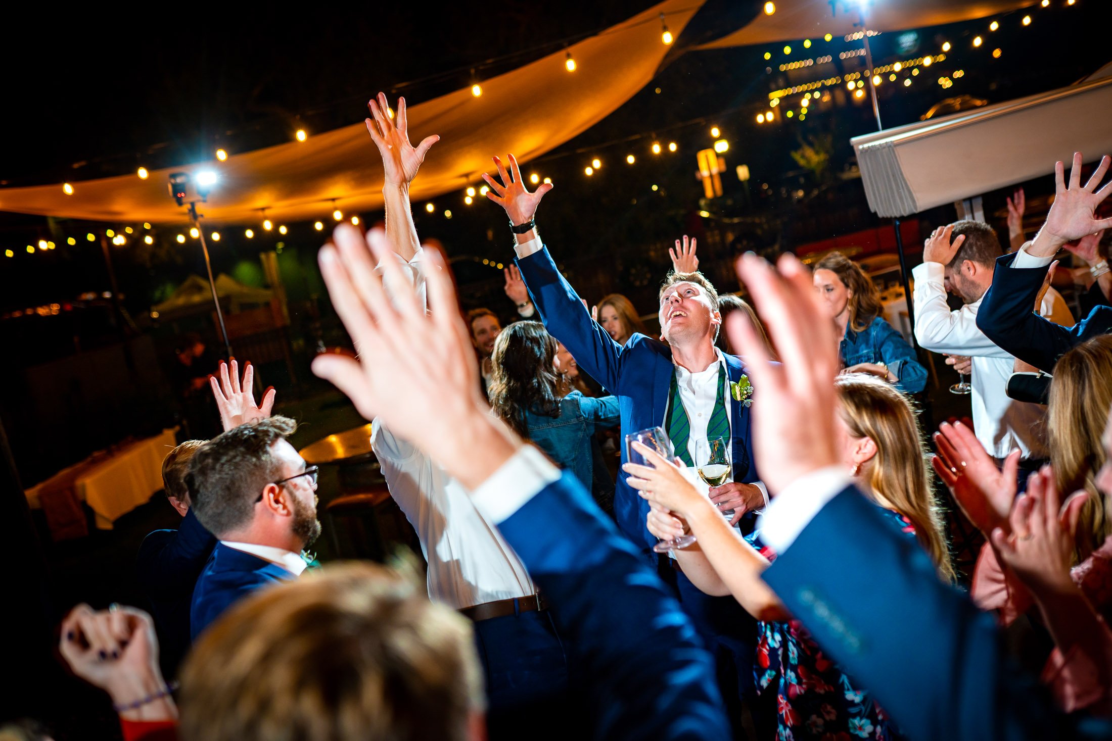 Guests dance to music on the outdoor patio under cafe lights during the wedding reception, wedding, wedding photos, wedding photography, wedding photographer, wedding inspiration, wedding photo inspiration, wedding portraits, wedding ceremony, wedding reception, mountain wedding, Catholic Church wedding, Catholic Church wedding photos, Catholic Church wedding photography, Catholic Church wedding photographer, Catholic Church wedding inspiration, Catholic Church wedding venue, Steamboat Springs wedding, Steamboat Springs wedding photos, Steamboat Springs wedding photography, Steamboat Springs wedding photographer, Colorado wedding, Colorado wedding photos, Colorado wedding photography, Colorado wedding photographer, Colorado mountain wedding, Colorado wedding inspiration