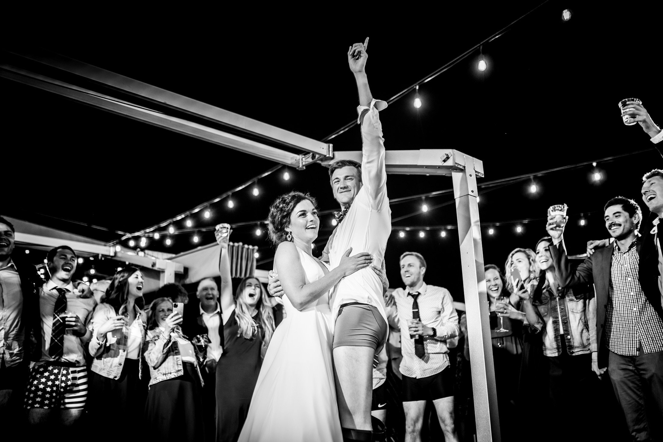 Bride and groom dance together while groom is wearing only his boxers on the outdoor patio under cafe lights during the wedding reception, wedding, wedding photos, wedding photography, wedding photographer, wedding inspiration, wedding photo inspiration, wedding portraits, wedding ceremony, wedding reception, mountain wedding, Catholic Church wedding, Catholic Church wedding photos, Catholic Church wedding photography, Catholic Church wedding photographer, Catholic Church wedding inspiration, Catholic Church wedding venue, Steamboat Springs wedding, Steamboat Springs wedding photos, Steamboat Springs wedding photography, Steamboat Springs wedding photographer, Colorado wedding, Colorado wedding photos, Colorado wedding photography, Colorado wedding photographer, Colorado mountain wedding, Colorado wedding inspiration