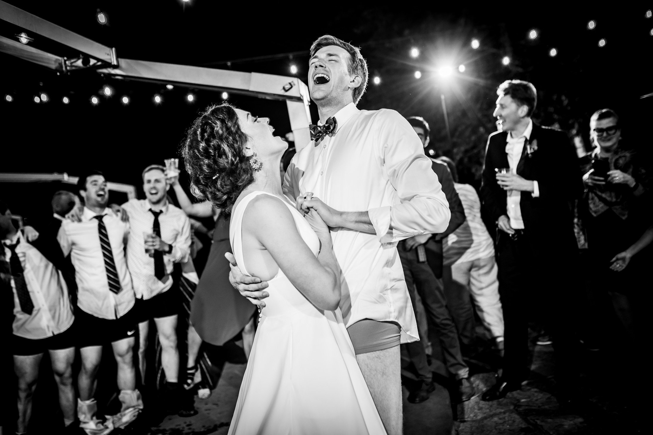 Bride and groom dance together while groom is wearing only his boxers on the outdoor patio under cafe lights during the wedding reception, wedding, wedding photos, wedding photography, wedding photographer, wedding inspiration, wedding photo inspiration, wedding portraits, wedding ceremony, wedding reception, mountain wedding, Catholic Church wedding, Catholic Church wedding photos, Catholic Church wedding photography, Catholic Church wedding photographer, Catholic Church wedding inspiration, Catholic Church wedding venue, Steamboat Springs wedding, Steamboat Springs wedding photos, Steamboat Springs wedding photography, Steamboat Springs wedding photographer, Colorado wedding, Colorado wedding photos, Colorado wedding photography, Colorado wedding photographer, Colorado mountain wedding, Colorado wedding inspiration