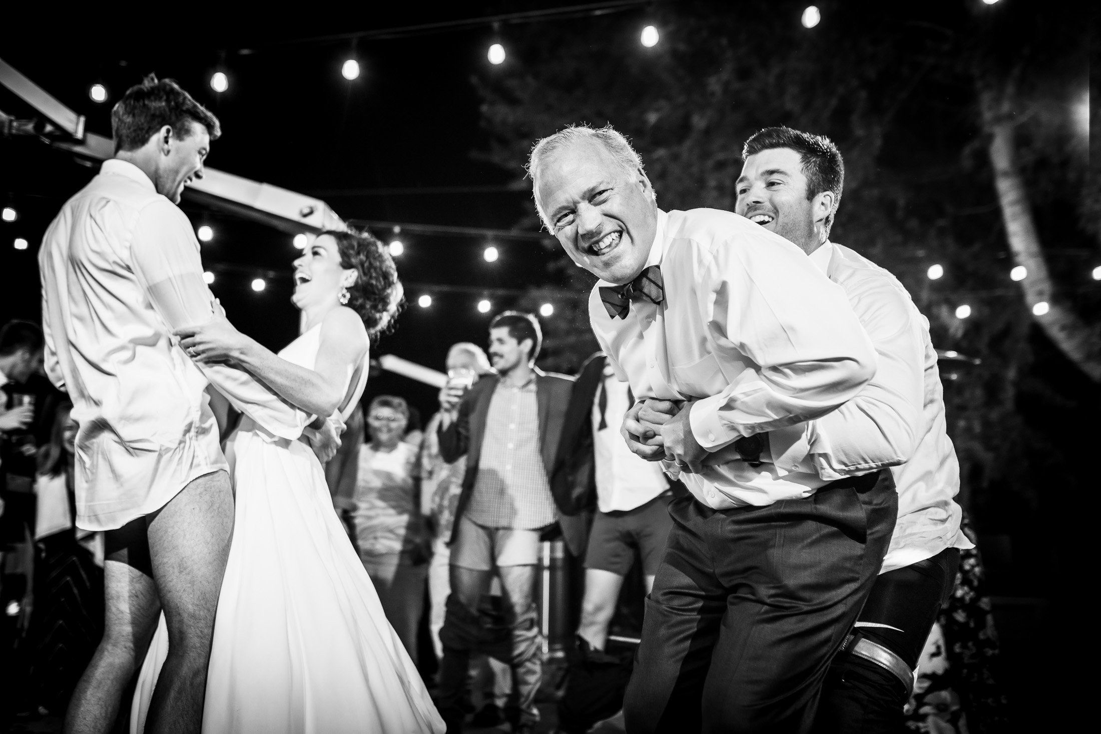 Bride and groom dance together while groom is wearing only his boxers on the outdoor patio under cafe lights during the wedding reception, wedding, wedding photos, wedding photography, wedding photographer, wedding inspiration, wedding photo inspiration, wedding portraits, wedding ceremony, wedding reception, mountain wedding, Catholic Church wedding, Catholic Church wedding photos, Catholic Church wedding photography, Catholic Church wedding photographer, Catholic Church wedding inspiration, Catholic Church wedding venue, Steamboat Springs wedding, Steamboat Springs wedding photos, Steamboat Springs wedding photography, Steamboat Springs wedding photographer, Colorado wedding, Colorado wedding photos, Colorado wedding photography, Colorado wedding photographer, Colorado mountain wedding, Colorado wedding inspiration